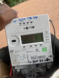 A hand holding a smart electricity meter.
